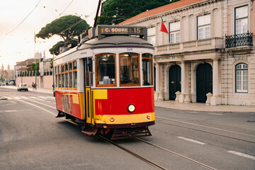 Iconic vintage yellow tram 15 traversing the charming streets of Lisbon, Portugal, a symbol of the...
