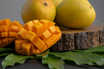 Mango tropical fruit with slice and half cut on green leaf background