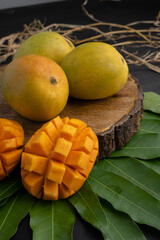 Mango tropical fruit with slice and half cut on green leaf background
