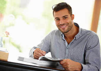 Portrait, man and smile with book, studying and learning for education, university or college. Male person, student and happy with textbook, information and course for research, development and phd