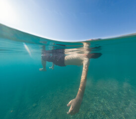 Young male on holidays enjoy floating on a crystal clear water beach of Antalya Turkey. Man...
