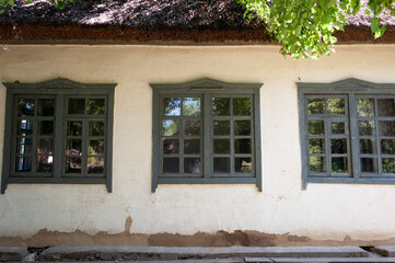 Fototapeta na wymiar Windows in the village house building. Village house architecture with three windows