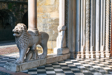 Lion statue in the courtyard of the Cathedral, marble columns background