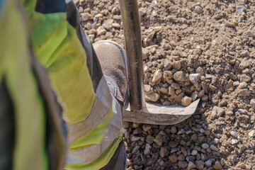 Łopata „operator” - kopanie żwiru na placu budowy. Kopanie żwiru w celu wyrównania poziomu kruszonego kamienia wylanego na fundament.