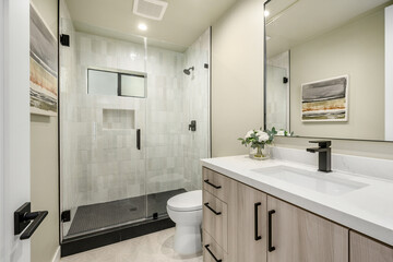 a bathroom with a shower and a double sink counter and toilet
