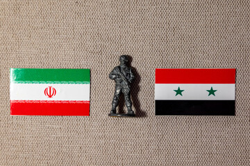 A soldier figurine on the background of the flags of Iran and Syria