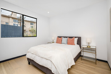 the large bed in the bedroom has white pillows and orange pillows on it