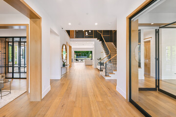 a house foyer features hardwood floors and modern staircases and wooden floors