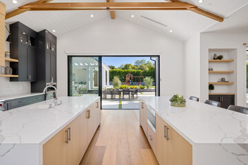 an all white kitchen with natural wood and a large dining area