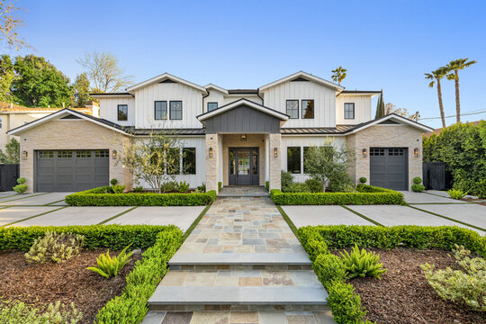 a house with driveway and stairs leading to the front door