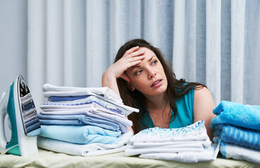 Laundry, stress headache and woman in home with mess, clothes and clutter in apartment. Spring...