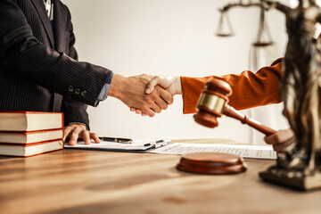 Shaking hands signifies mutual agreement and professionalism. It embodies the essence of justice, with lawyers, judges, and authorities collaborating within the framework of law and judgment.