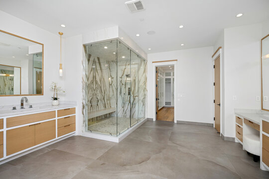 a large bathroom with shower and vanity area for the couple
