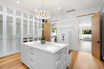 a clean white kitchen has lots of cupboards and glass doors