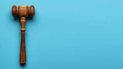 Wooden gavel on a light blue background.