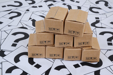Shipping carton boxes on question marks background.	
