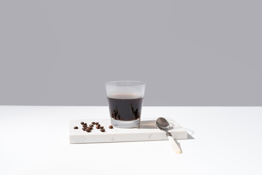 Vaso de café negro sobre mármol y fondo gris	