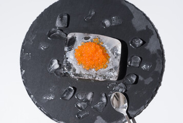 Caviar de salmón sobre hielo en un plato de pizarra. Comida gourmet. Vista superior