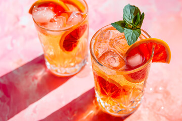 long drink or cocktail with ice and orange, ice tea, refreshment in the summer, shadows and high contrast