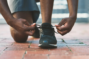 Feet, sport and shoes tie on pavement with person and athlete for running and jog. Shoelace,...