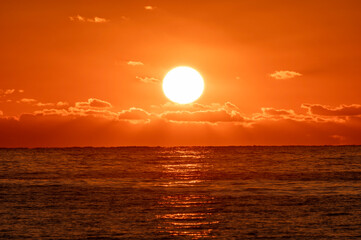朝日に照らされてオレンジ色に染まる海