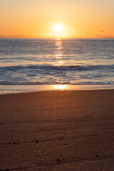 Fototapeta na wymiar 海から登った太陽に照らされる海とビーチ