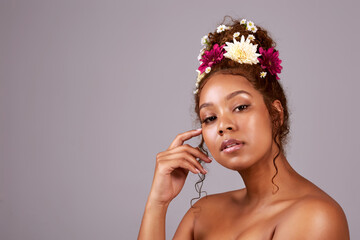 Beauty, black woman and natural care portrait with eco friendly makeup and flowers in studio....