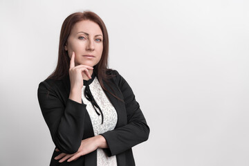 Portrait thoughtful middle adult businesswoman wearing formal dress touching chin, standing on white