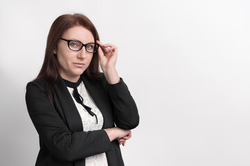 Formal portrait of well dressed businesswoman, wearing jacket and glasses, looking at camera