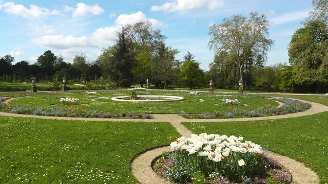 Pan over the rose garden in the Bagatelle park at springtime. It was built in 1835. It is located in Boulogne-Billancourt near Paris, France