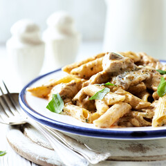 Penne Pasta baked with Meat on bright wooden Background. Close up.
