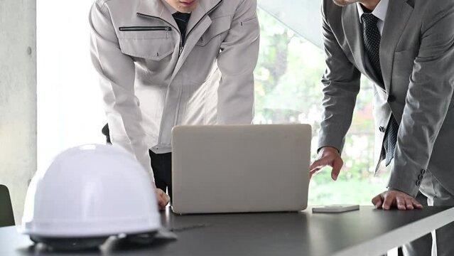 施工図を確認する現場監督と施工管理技士　ビルの設計や施工管理などのイメージ　顔無しの動画