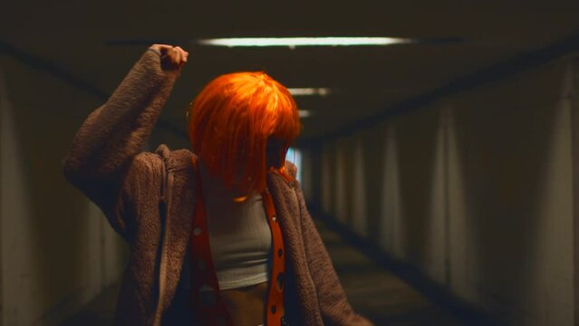 Girl dancing. stylish young woman with orange hair dances in a nightclub. Music, dancing and partying with women at the concert.