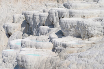 Pamukkale is a natural site in Denizli Province in southwestern Turkey. The area is famous for a carbonate mineral left by the flowing of thermal spring water.	
