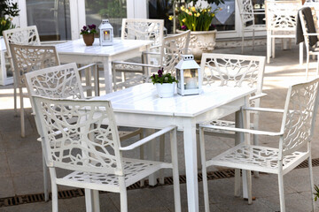 Cozy street cafe with empty tables on a sunny day.