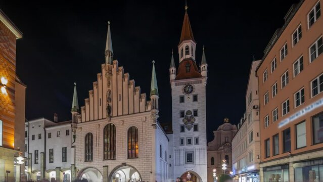 Marienplatz with the old Munich town hall (Altes Rathaus) and the Talburg Gate night timelapse hyperlapse, Illuminated tower with clock. Munchen-Altstadt, Bavaria, Germany.