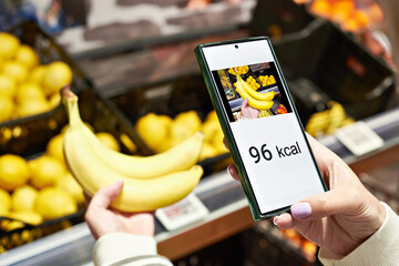 Checking calories on banana in store with smartphone
