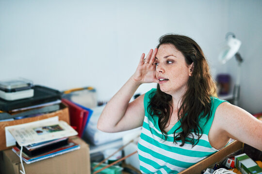 Cleaning, stress and woman in home with chores, boxes of junk and clutter in living room chaos. Housekeeping, fatigue and frustrated female person with anger, burnout and dirt crisis in apartment