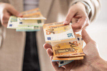 Businesswoman's hands exchanging euro banknotes, closeup shot - 783800111