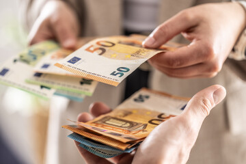 Businesswoman's hands exchanging euro banknotes, closeup shot - 783800116