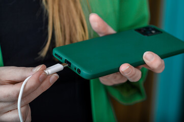 Dziewczyna podłącza telefon komórkowy do ładowarki 