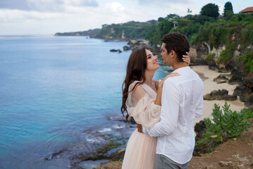 Newlyweds share a tender hug by the tropical seashore