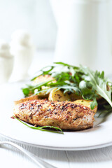 Grilled Chicken Breast with oven baked potatoes and fresh rocket. Bright background. Close up.
