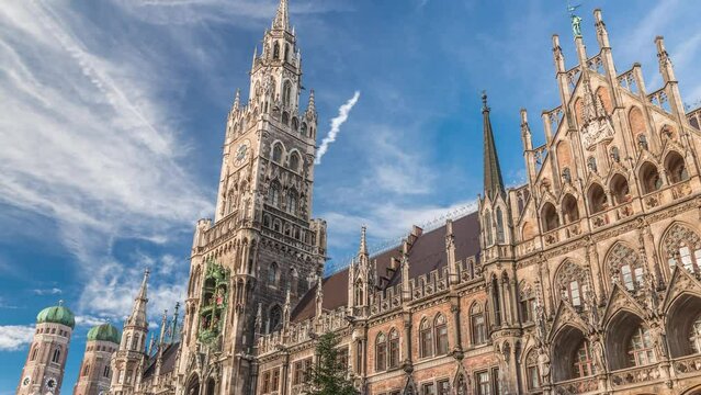 Marienplazt Old Town Square with the New Town Hall timelapse. Neues Rathaus and Town Hall Clock Tower Glockenspiel. Munich skyline, downtown cityscape with clouds on a blue sky. Bavaria, Germany