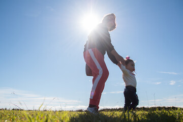 Madre e hija caminando en el césped durante un día de sol