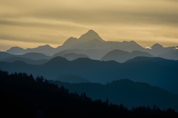 Obraz premium Majestic mountain peak silhouette backlit by yellow sunrise