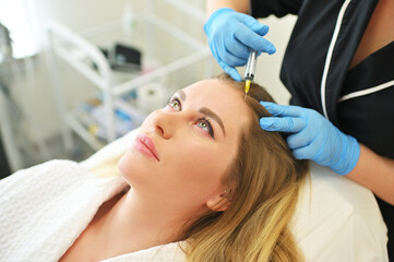 dermatologist cosmetologist performs a mesotherapy procedure and injects an injection into the...