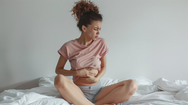Woman in abdominal pain concept. Suffering pain causing illness such as endometriosis, IBS, menstruation period cramps, fibromyalgia,  diarrhoea, or cystitis