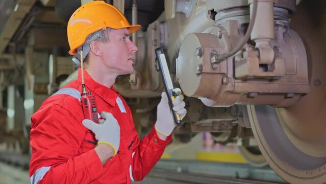 Professional technician worker hold light tube to check and maintenance part of train in electrical or metro train factory.