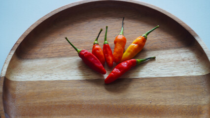 Isolated flat lay cayenne pepper or Capsicum annuum also commonly called Birds Eye on a wooden...